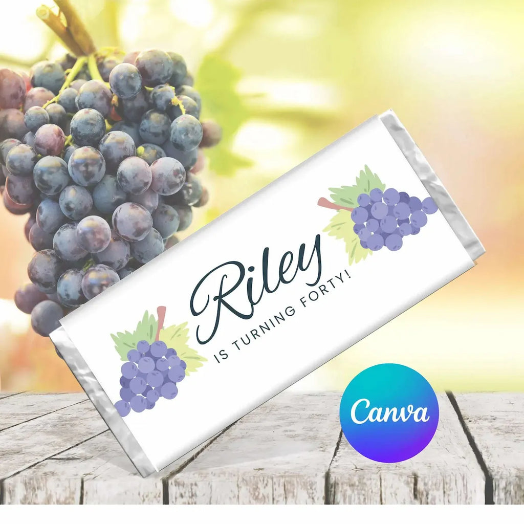 Personalized chocolate bar with grapes and text 'Riley is turning forty!' on a wooden surface with grapes in the background.
