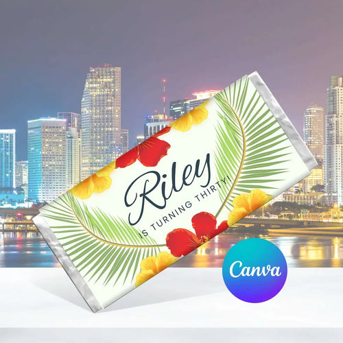 A tropical-themed birthday chocolate bar wrapper featuring palm leaves and hibiscus flowers, with the text 'Riley IS TURNING THIRTY!' and a Canva logo badge on a city skyline background.