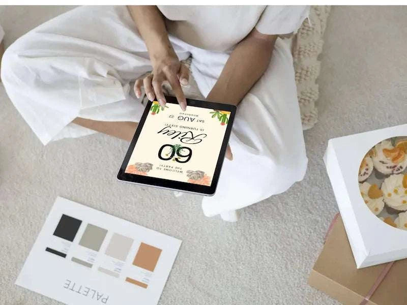 Sedona 60th Editable Birthday Invitation tablet being held by human sitting on carpeted floor. 